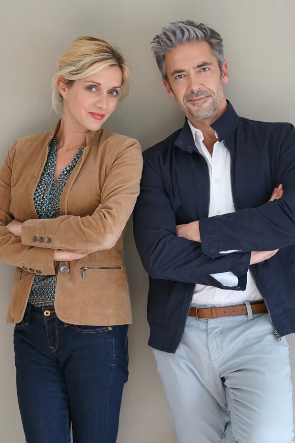 Hyperthyroidism-Treatment A middle-aged couple stand against a wall smiling with folded arms. Get hyperthyroidism treatment from Marina Fay, PA-C in Aventura-North Miami.