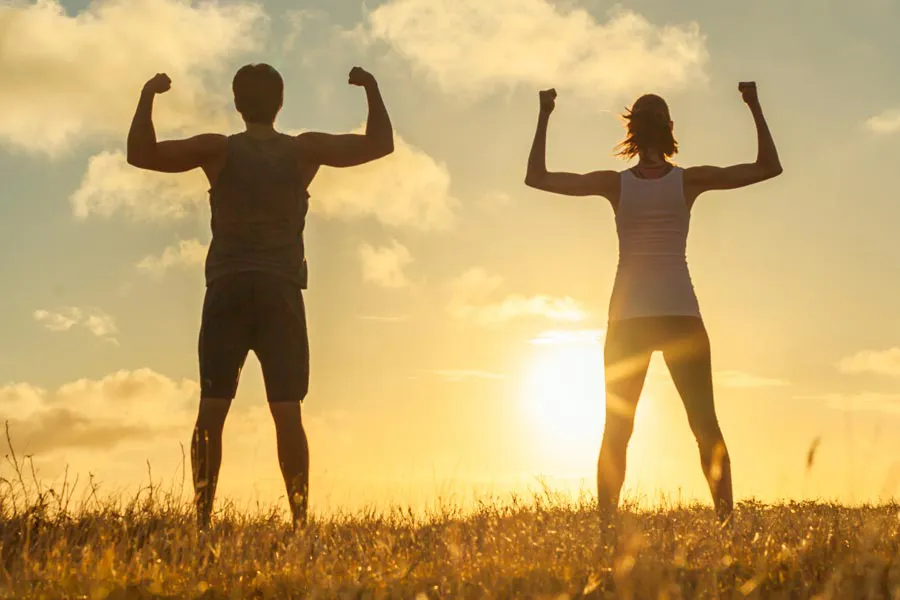 Immune-Optimization-Peptides-Clinic A couple flex their arms outside in the sunrise. Schedule Immune Optimization Peptide Treatment from Marina Fay, PA-C in Aventura-North Miami.