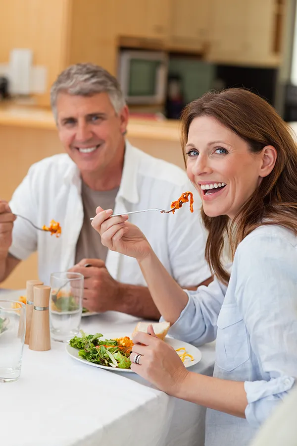 Leaky-Gut-Syndrome-Treatment Improve digestion with Marina Fay, PA-C's Functional Medicine for Leaky Gut Syndrome care in Aventura-North Miami, featuring a happy couple enjoying a nutritious lunch at home.