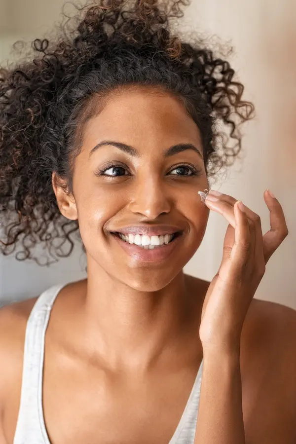 Matrixyl-Peptide-Therapy-Treatment A beautiful black woman applies facial cream. Get Matrixyl peptide therapy from Marina Fay, PA-C in Aventura-North Miami.