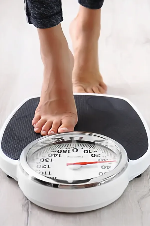 Metabolilc-and-Weight-Optimization-Peptides-Treatment A woman steps onto a scale. Get Metabolilc and Weight Optimization Peptides treatment from Marina Fay, PA-C in Aventura-North Miami.