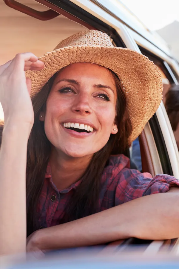 Microneedling-With-PRF-Treatment A woman in a sunhat leans out a car window. Get Microneedling with PRF from Marina Fay, PA-C in Aventura-North Miami.