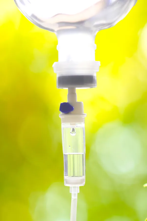 NAD-Therapy-Treatment Close up of an IV drip with a lush, green background. Get NAD Therapy from Marina Fay, PA-C in Aventura-North Miami.