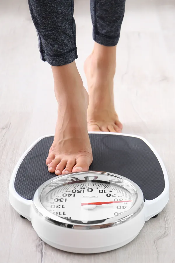 Obesity-Treatment Close up of feet stepping onto a scale. Receive expert functional medicine for obesity treatment by Marina Fay, PA-C in Aventura-North Miami.