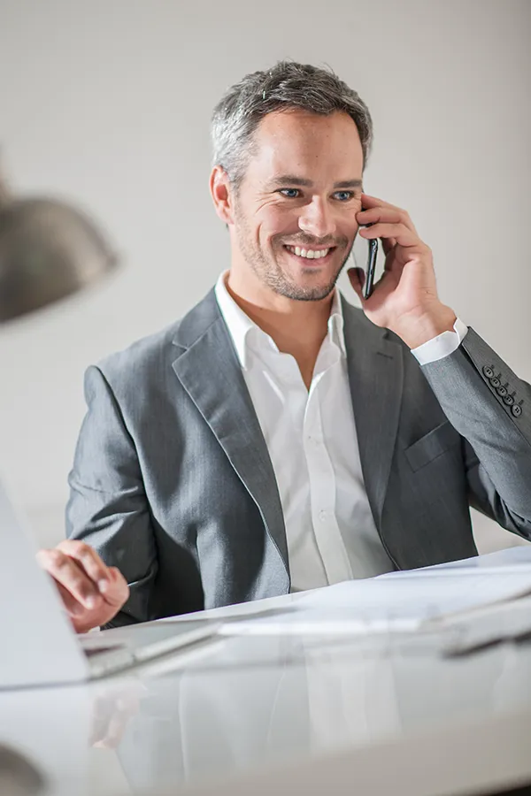 PRF-Hair-Restoration-Therapy-Treatment A business man with salt-and-pepper hair on the phone. Get PRF hair restoration therapy from Marina Fay, PA-C in Aventura-North Miami.