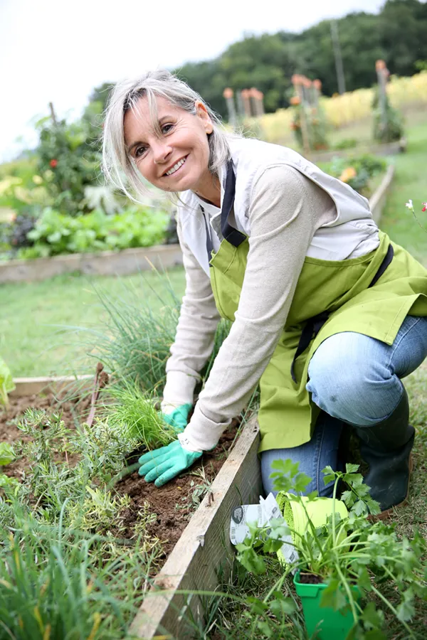 Rheumatoid-Arthritis-Treatment A mature woman bending down working on her garden happily after successful rheumatoid arthritis treatment from Marina Fay, PA-C in Aventura-North Miami.