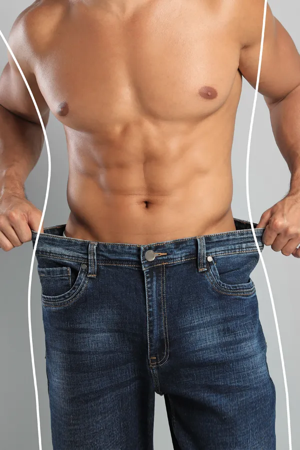 Semaglutide-Weight-Loss-Treatment A strong shirtless man in jeans holds the waistlines of his too-big jeans to show the success of semaglutide weight loss from Marina Fay, PA-C in Aventura-North Miami.