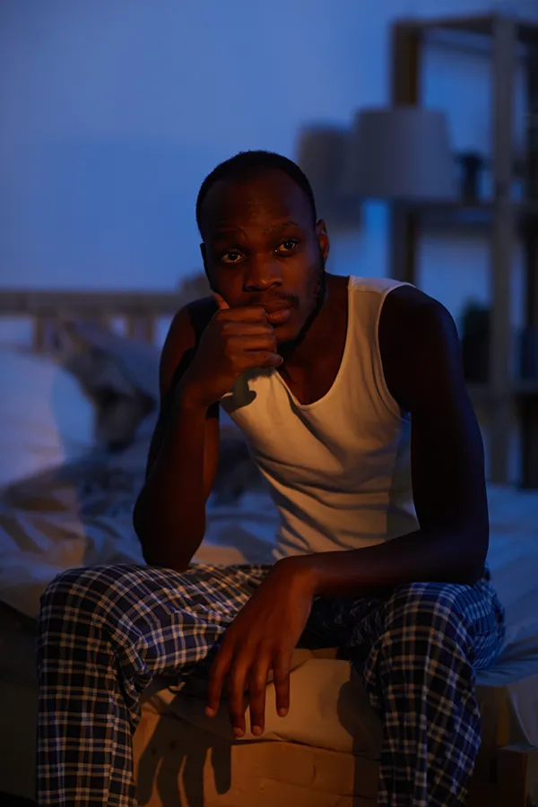 Sleep-Disorders-Treatment A man sits on the edge of his bed concerned that he can't sleep. Get treatment for sleep disorders from Marina Fay, PA-C in Aventura-North Miami.