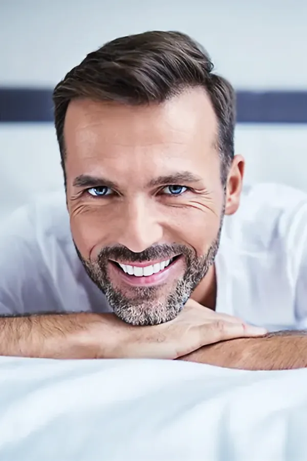 Sleep-Optimization-Strategies-Treatment A man lays on his stomach in bed with his head on his hands. Get consultation for sleep optimization strategies from Marina Fay, PA-C. in Aventura-North Miami.