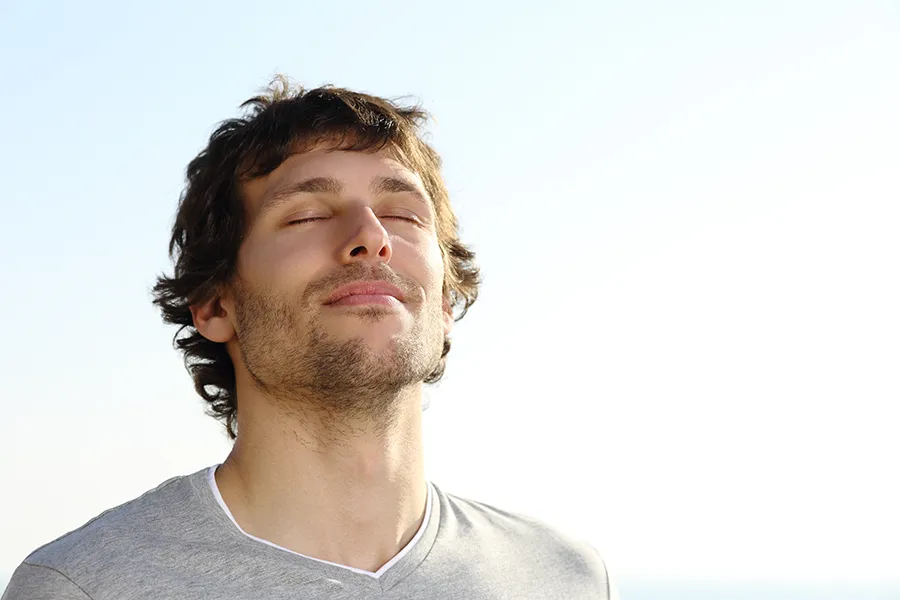 Stress-and-Mindfulness-Support-Clinic A man with closed eyes lifts his head to the sky. Get stress and mindfulness support from Marina Fay, PA-C in Aventura-North Miami.