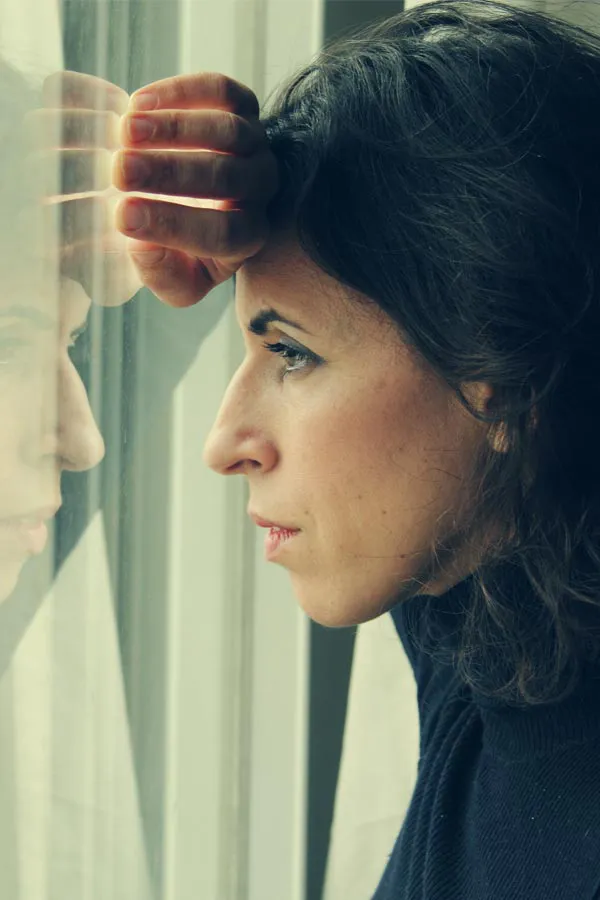 Stress-and-Mindfulness-Support-Treatment A troubled woman looks out the window. Get stress and mindfulness support from Marina Fay, PA-C in Aventura-North Miami.