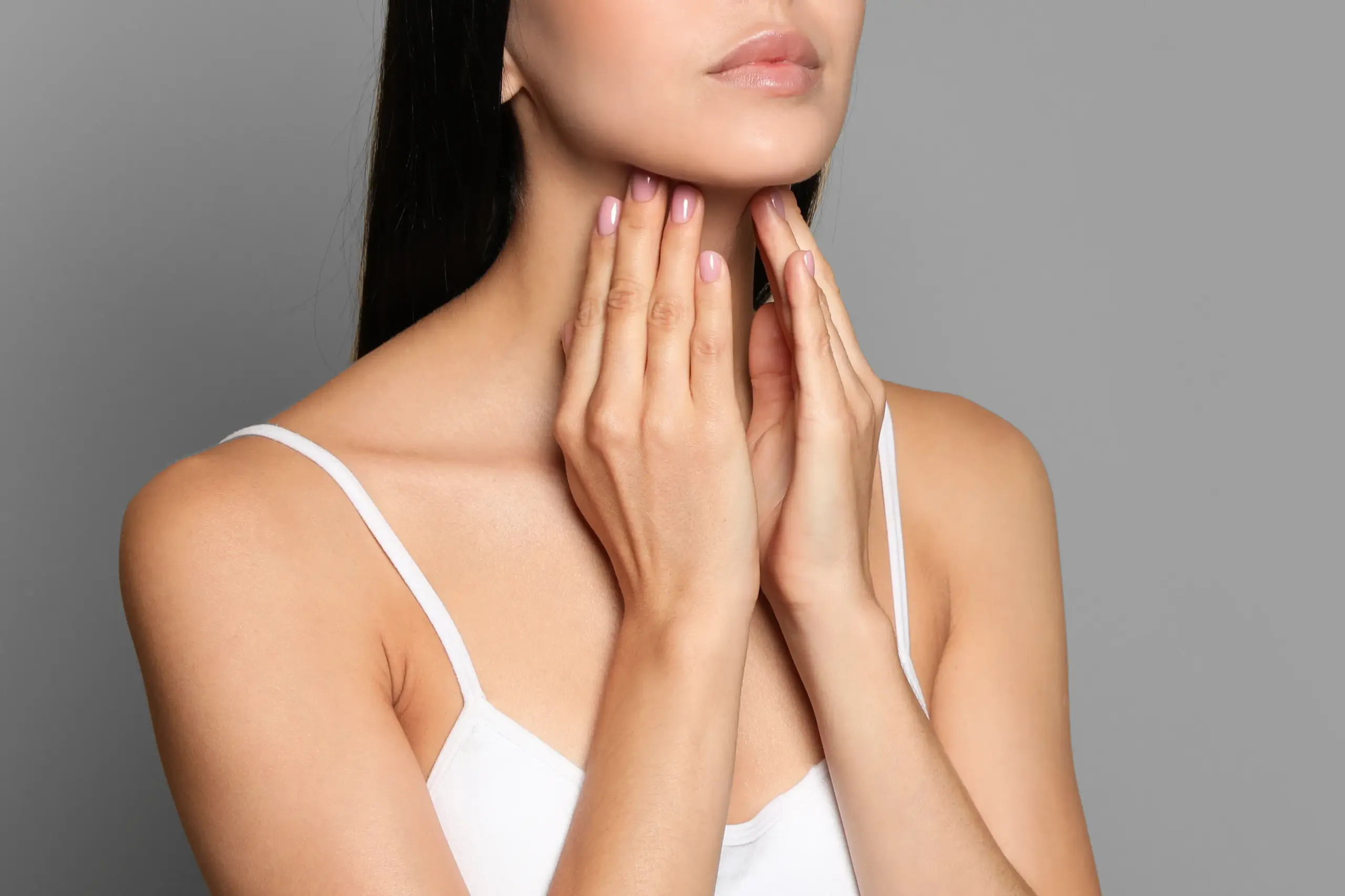 Thyroid-Doctor A woman in a white tank top touches her neck looking for signs of thyroid disorder. Get help for thyroid disorders from Marina Fay, PA-C in Aventura-North Miami.