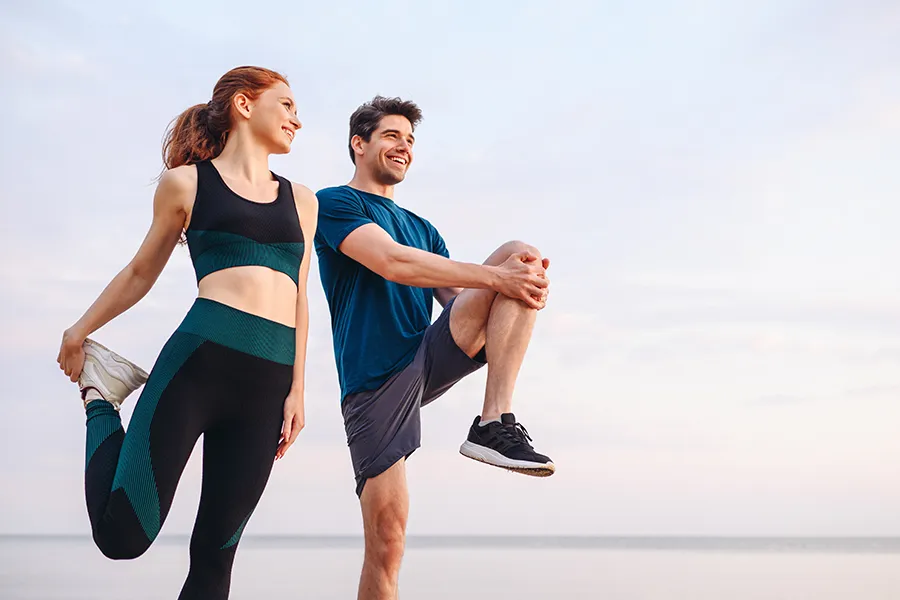 Tissue-Repair-and-Recovery-Peptides-Clinic A couple stretch before a run. Get Tissue Repair and Recovery Peptide Treatment from Marina Fay, PA-C in Aventura-North Miami.